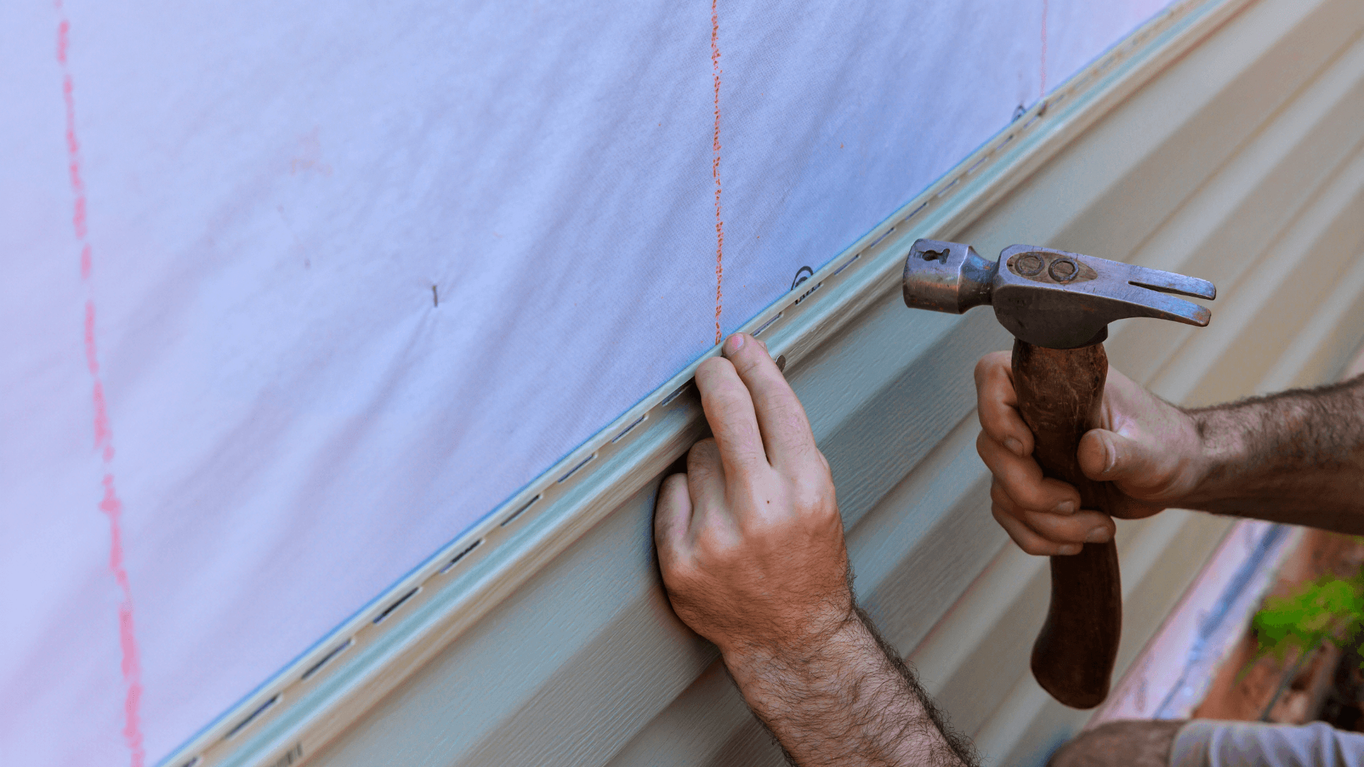 Man nailing in siding